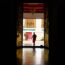 woman in red long sleeve shirt and pants walking on brown wooden floor