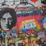 a wall covered in lots of graffiti with a picture of a man