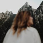 A woman standing in front of a mountain range