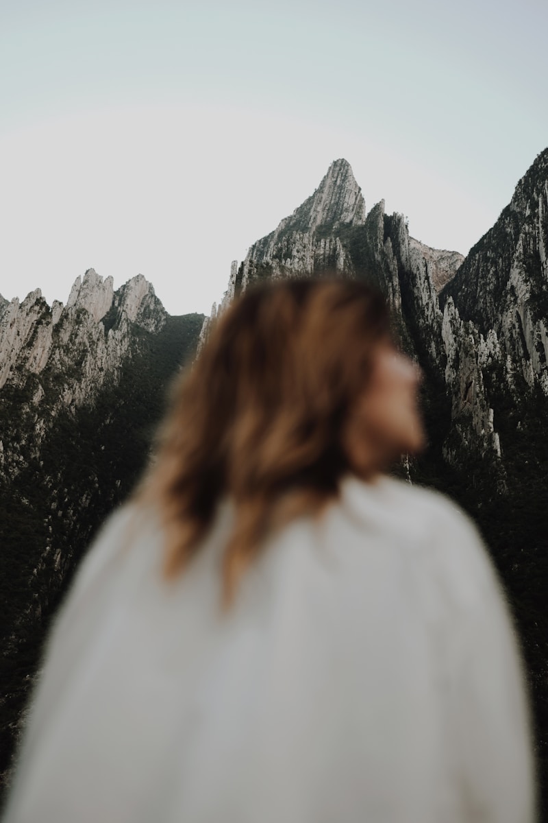 A woman standing in front of a mountain range