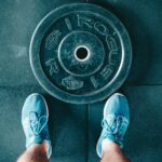 person standing beside black weights